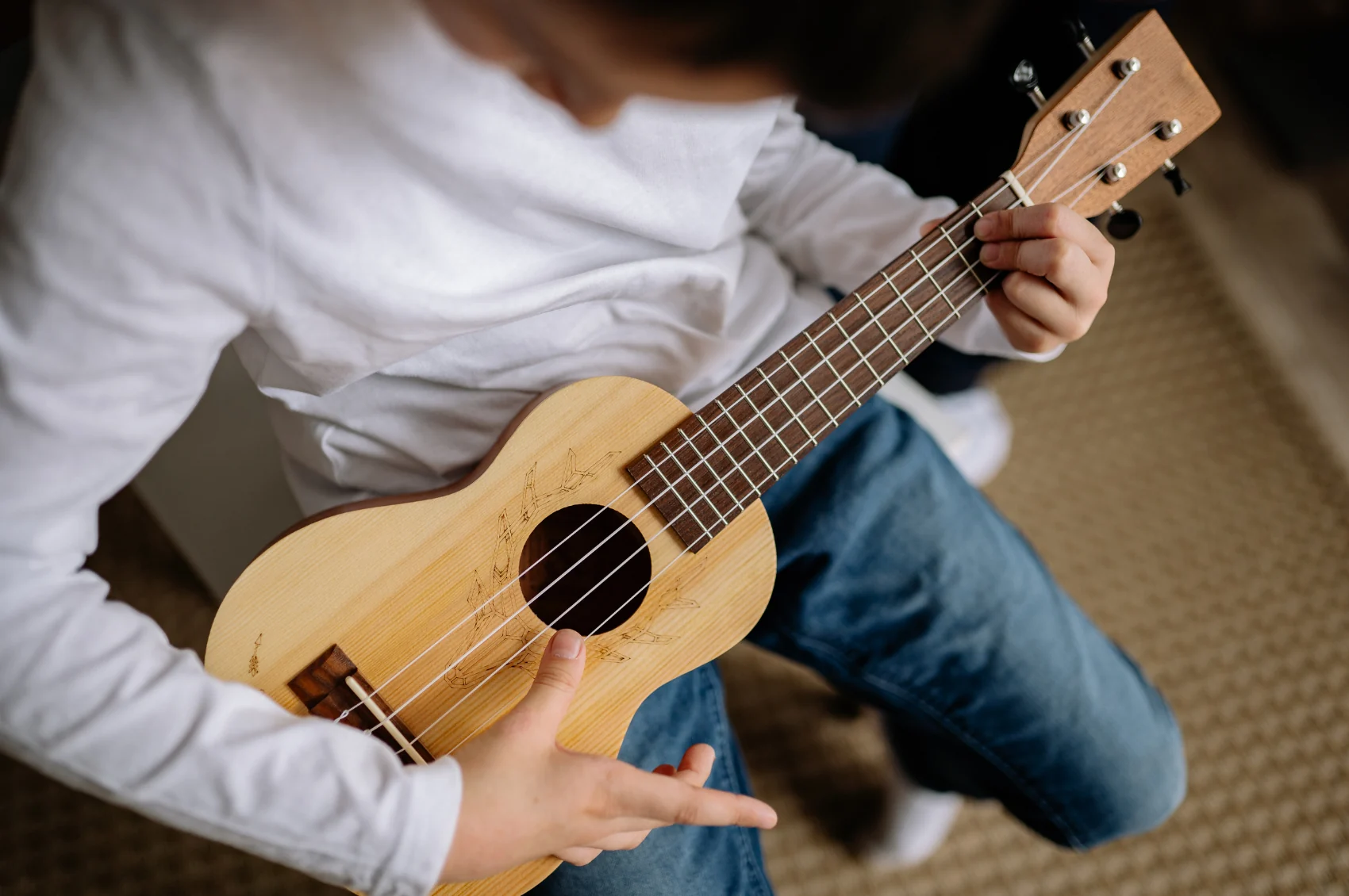 A child practicing chords on a ukulele