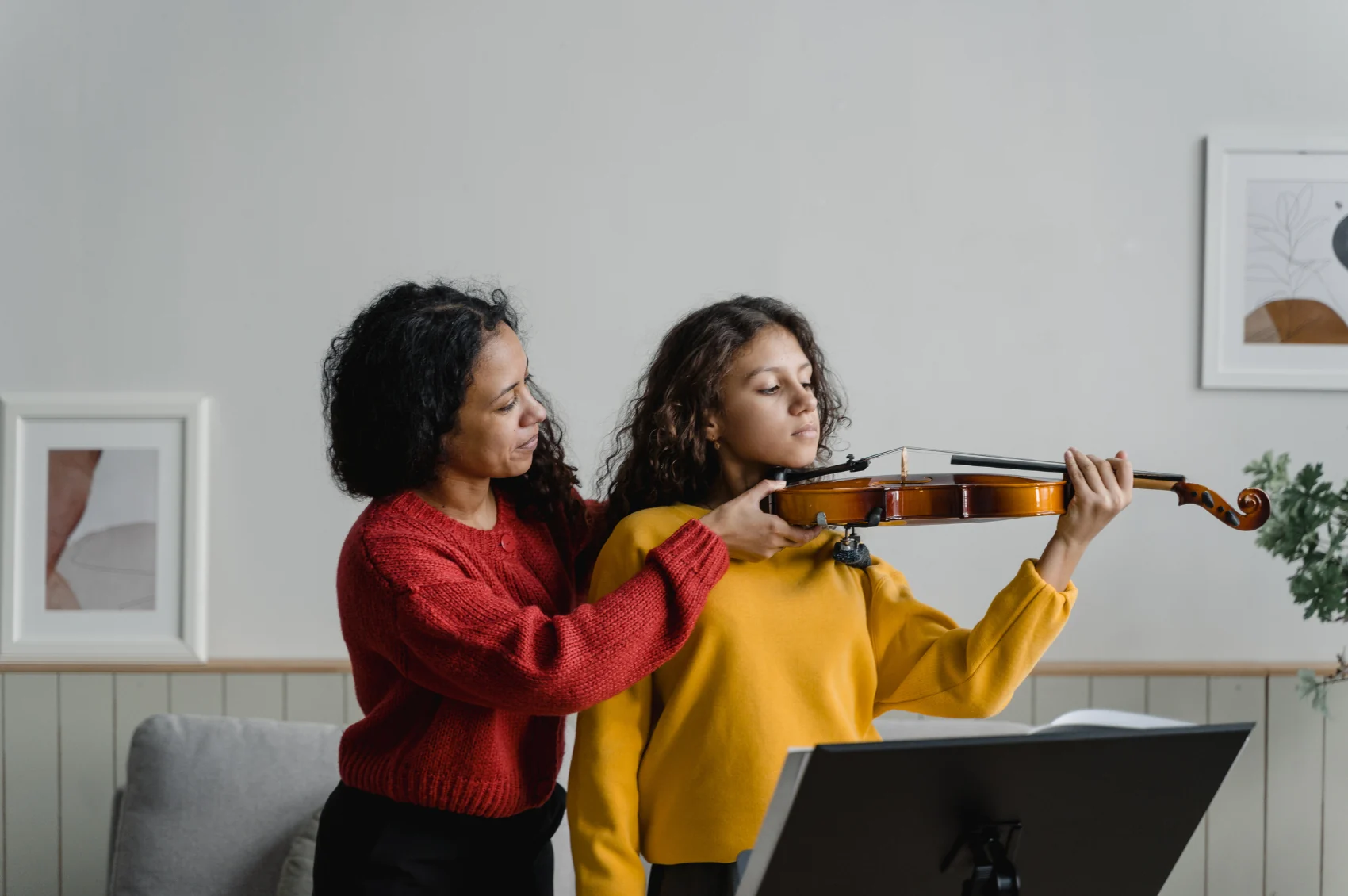 A teacher helping a student with violin technique
